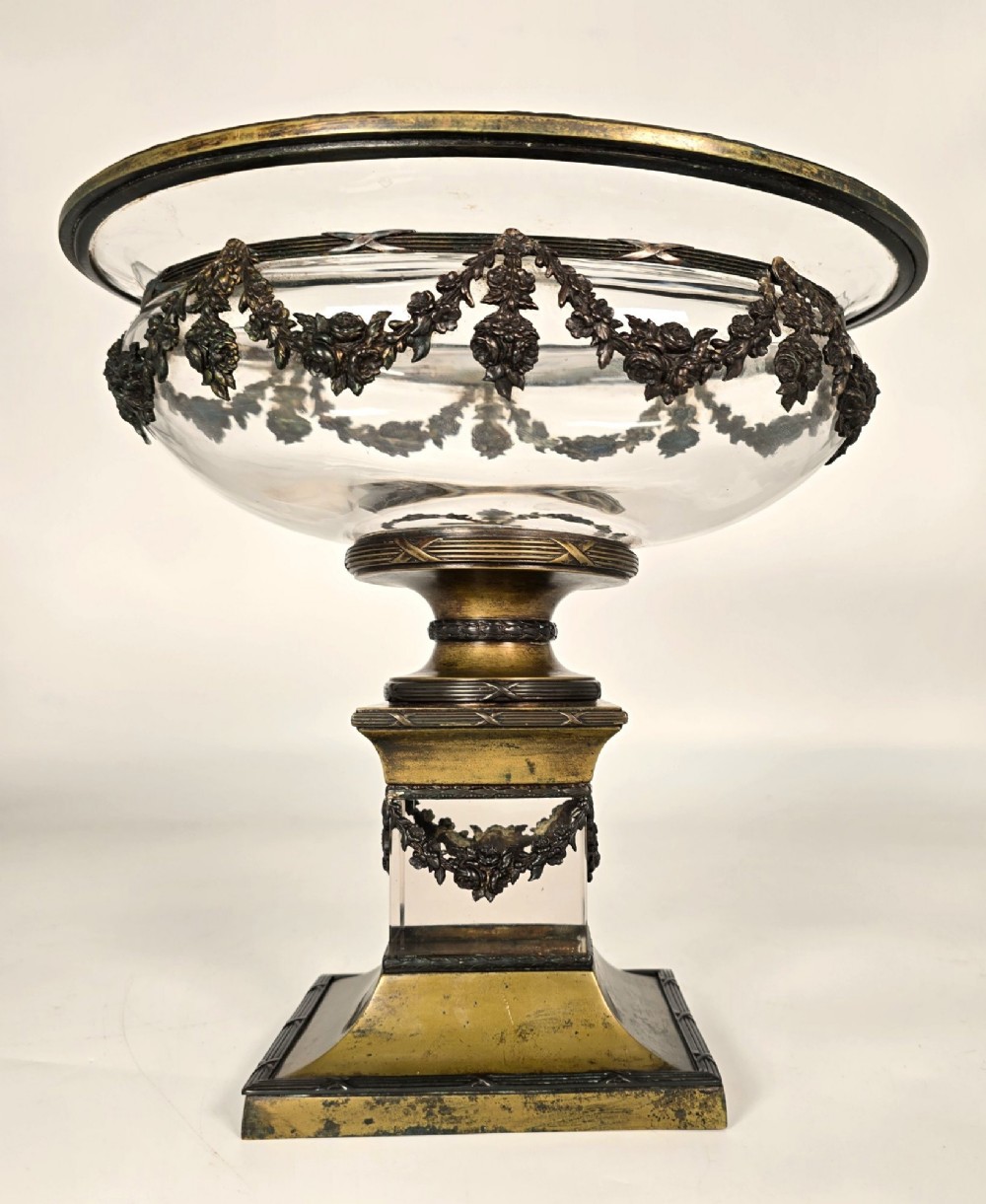 A clear glass bowl mounted with gilt-bronze floral swags and supported by a square stepped pedestal base. View II