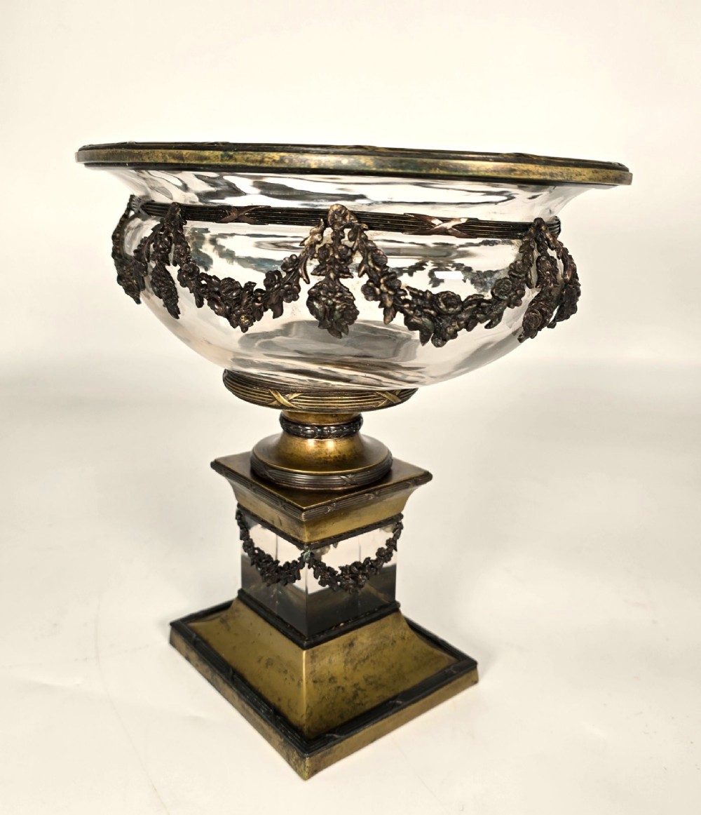 A clear glass bowl mounted with gilt-bronze floral swags and supported by a square stepped pedestal base. View VI