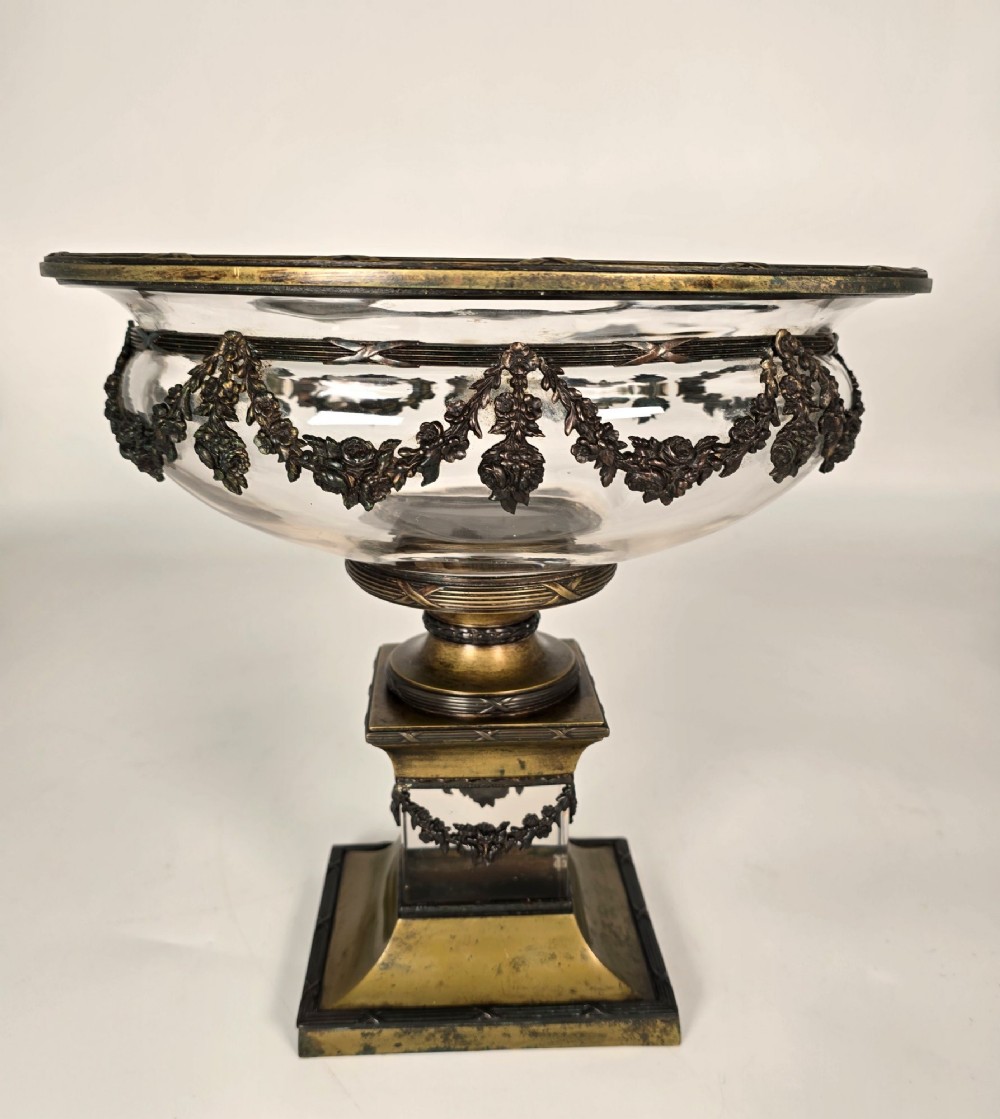 A clear glass bowl mounted with gilt-bronze floral swags and supported by a square stepped pedestal base. View VII