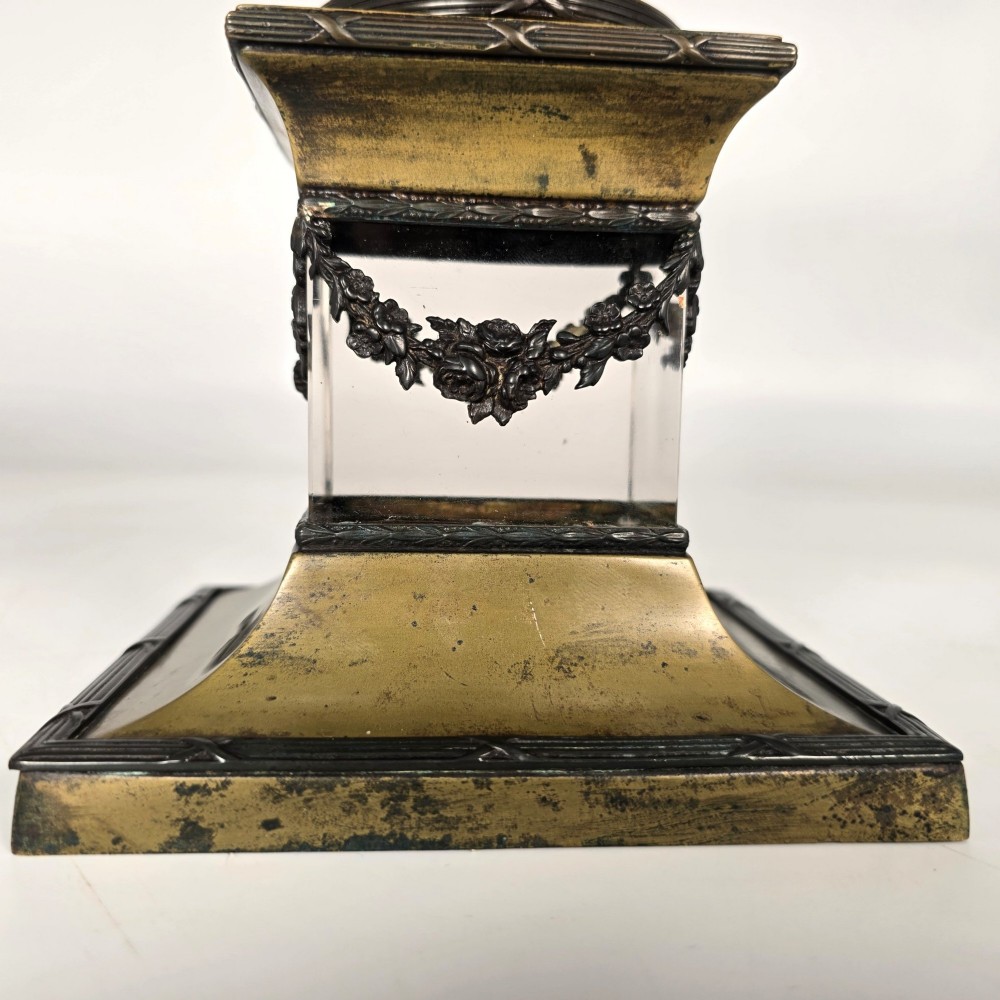 A clear glass bowl mounted with gilt-bronze floral swags and supported by a square stepped pedestal base. View X