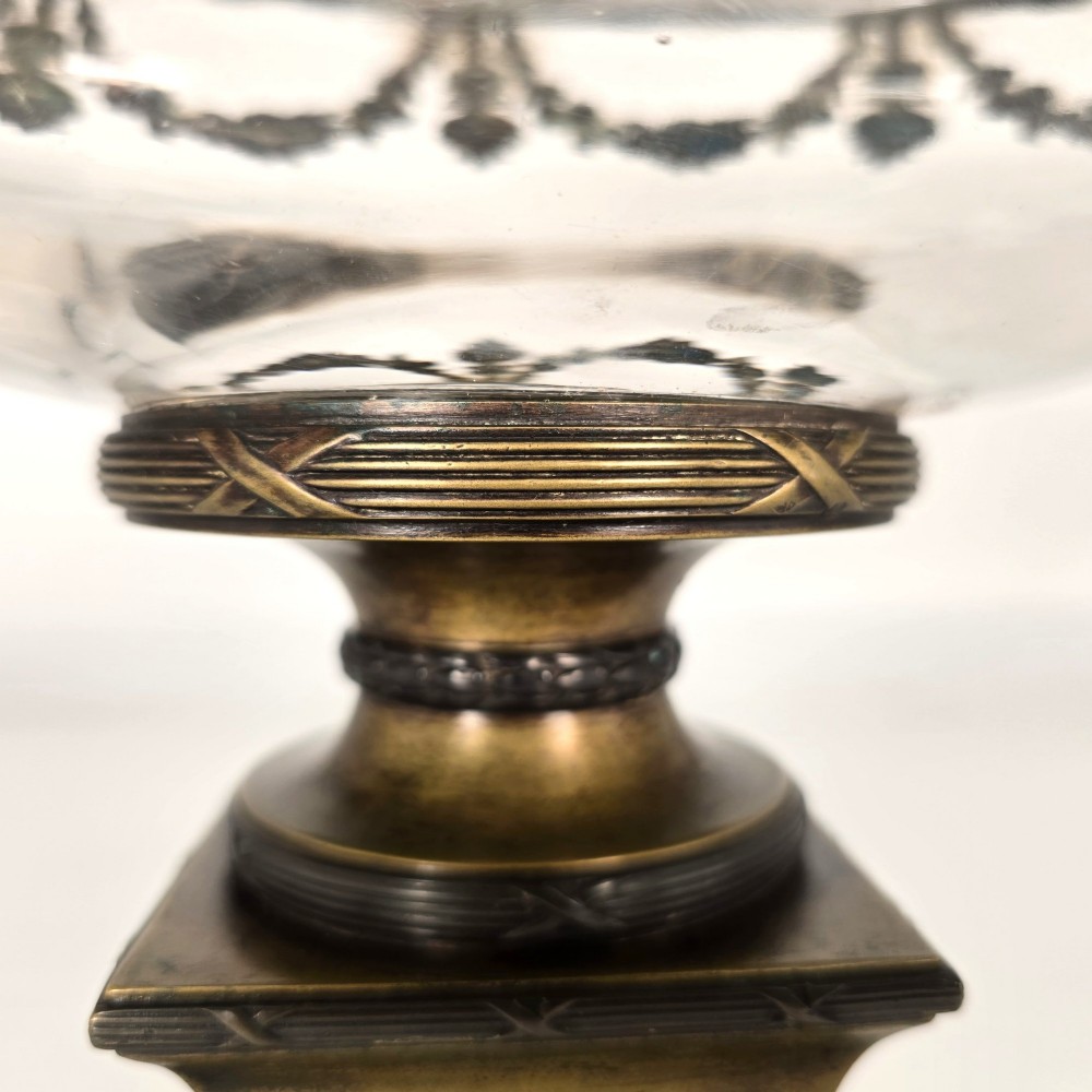 A clear glass bowl mounted with gilt-bronze floral swags and supported by a square stepped pedestal base. View XI