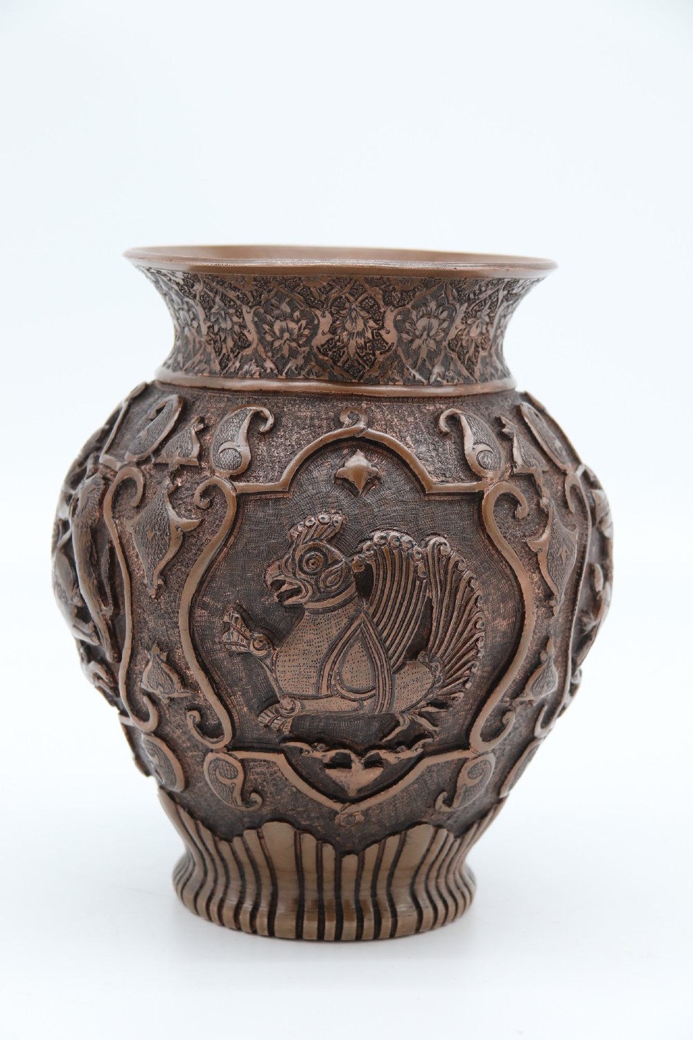 A bulbous late nineteenth-century copper vase featuring detailed repousse carvings of a mounted archer within a central cartouche surrounded by scrollwork and a fluted base. View III