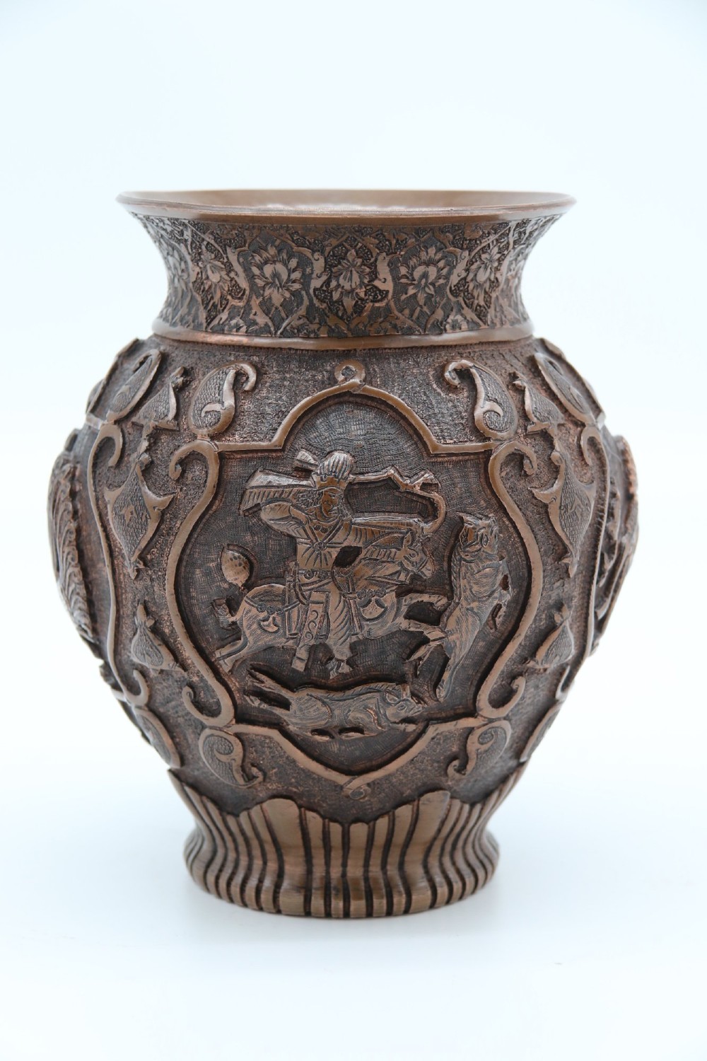 A bulbous late nineteenth-century copper vase featuring detailed repousse carvings of a mounted archer within a central cartouche surrounded by scrollwork and a fluted base. View V