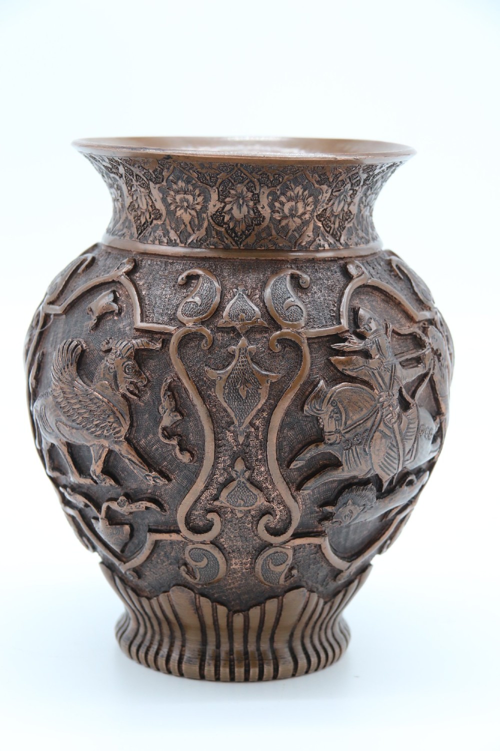 A bulbous late nineteenth-century copper vase featuring detailed repousse carvings of a mounted archer within a central cartouche surrounded by scrollwork and a fluted base. View VIII