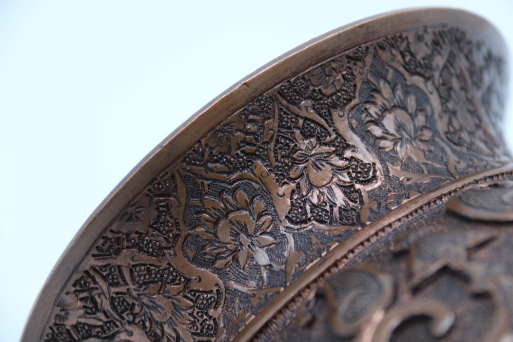 A bulbous late nineteenth-century copper vase featuring detailed repousse carvings of a mounted archer within a central cartouche surrounded by scrollwork and a fluted base. View XIV