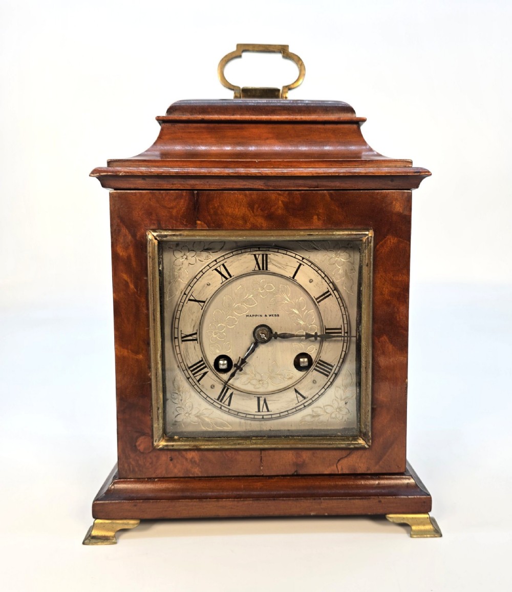 A miniature George II style wooden bracket clock featuring a caddy top with brass handle, engraved silvered dial with Roman numerals, and brass feet. View II