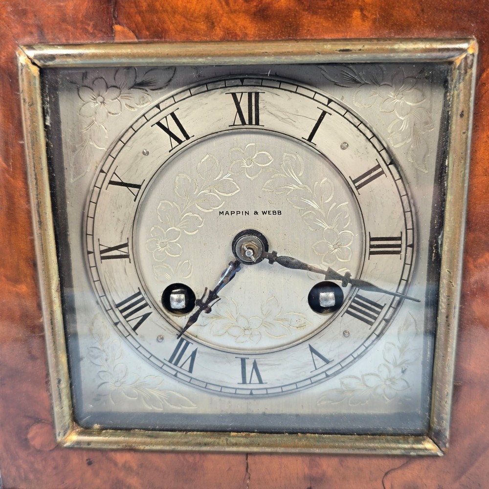 A miniature George II style wooden bracket clock featuring a caddy top with brass handle, engraved silvered dial with Roman numerals, and brass feet. View IX
