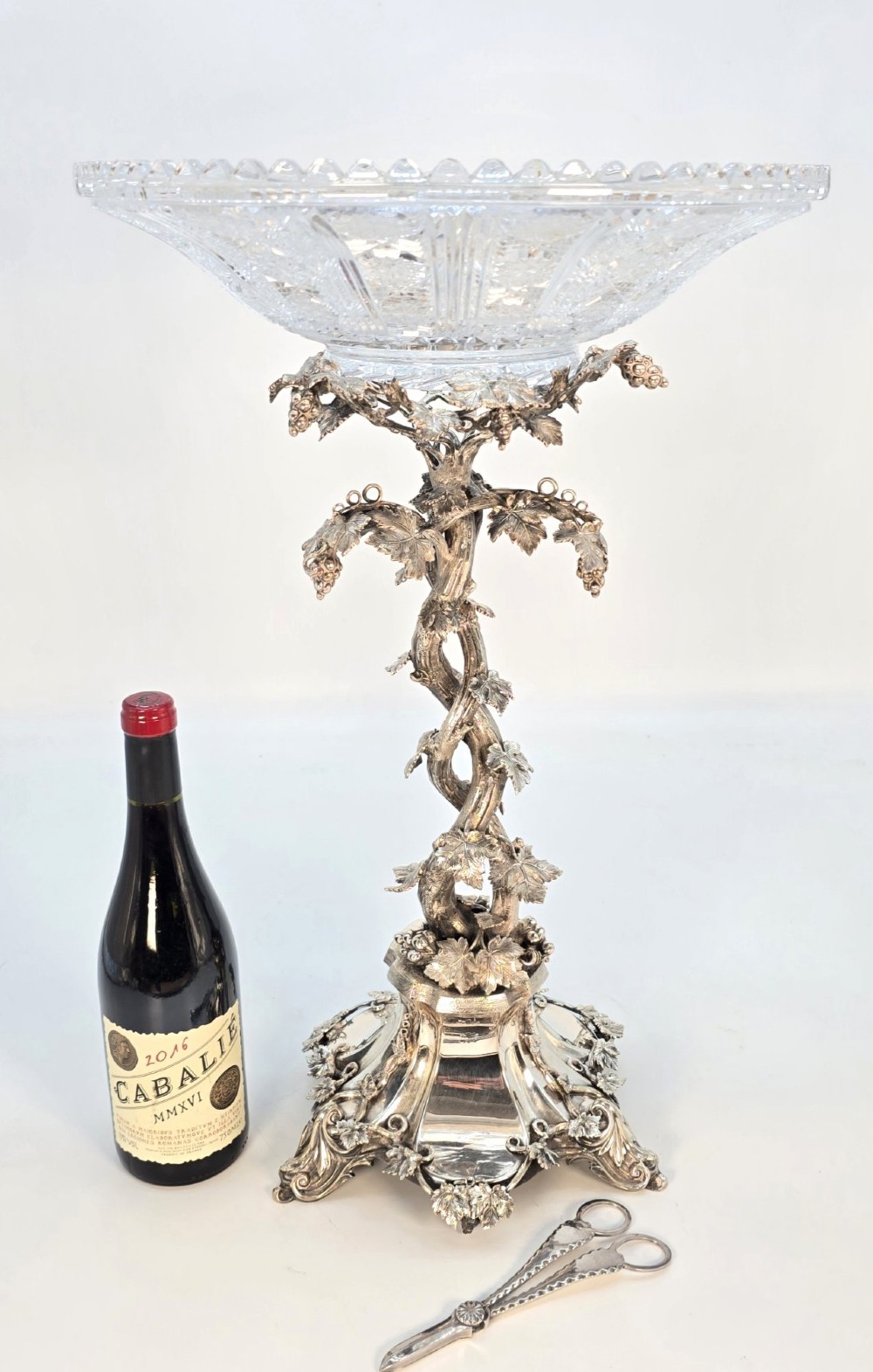 A Victorian silver-plated table centrepiece featuring an intertwined grapevine stem supporting a cut glass bowl.