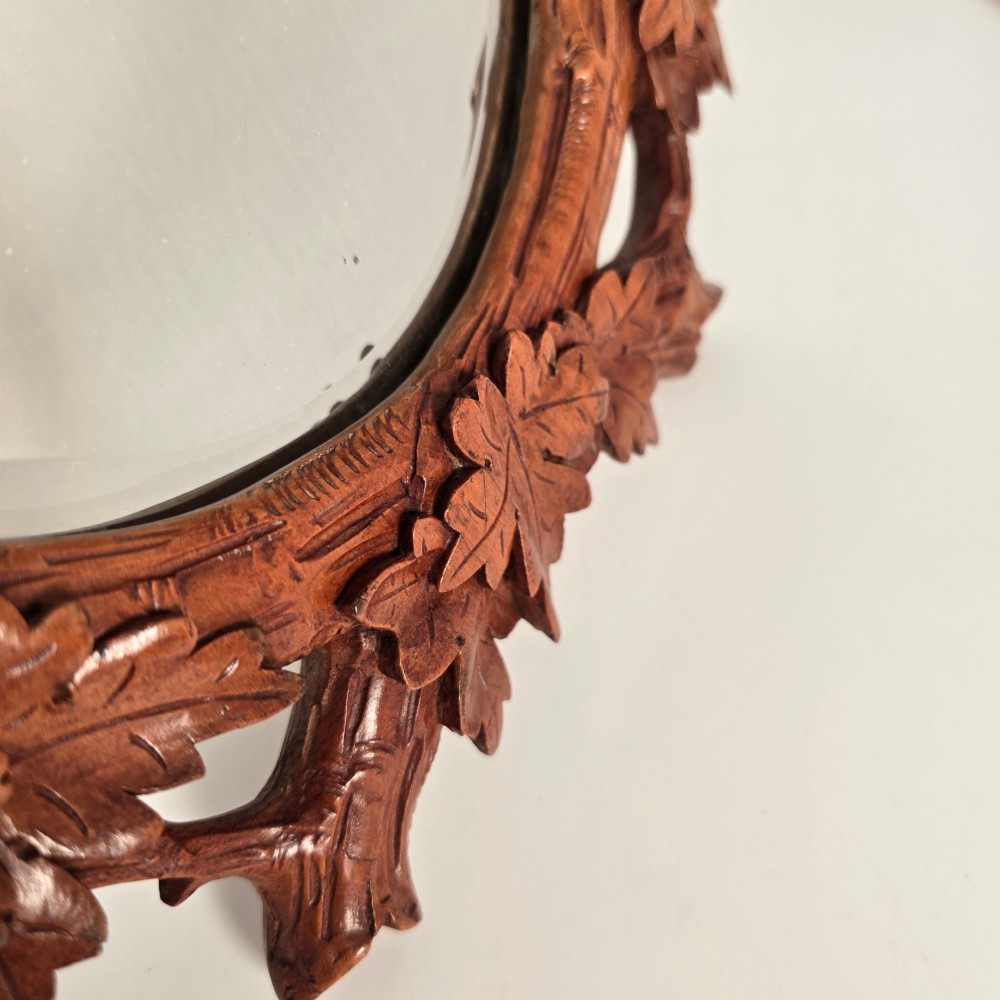 A late nineteenth-century Swiss carved lime wood oval table mirror surrounded by relief carvings of grapevine leaves and grapes. View IV