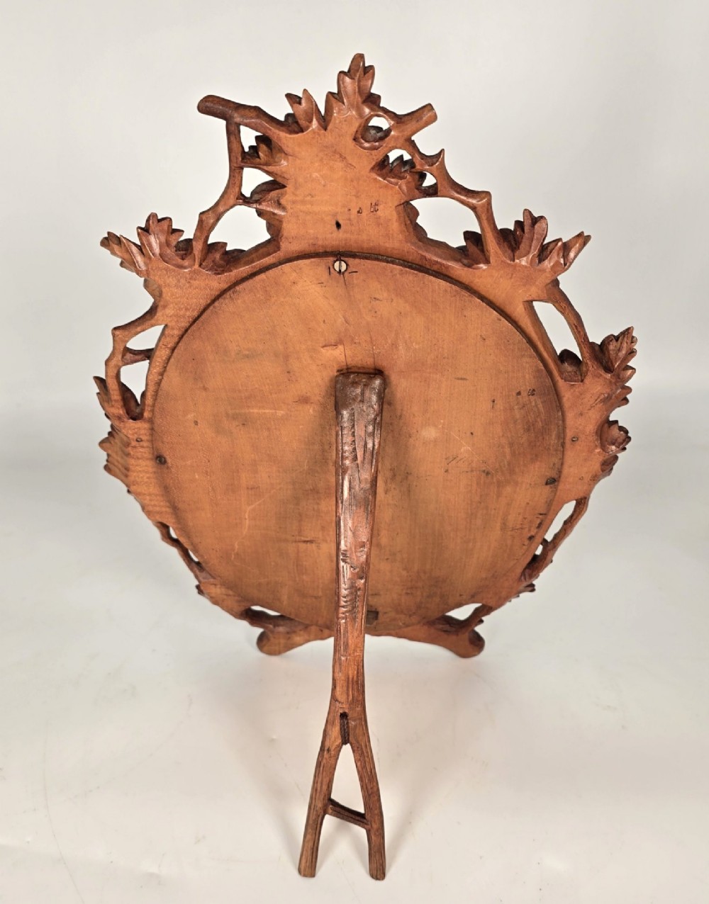 A late nineteenth-century Swiss carved lime wood oval table mirror surrounded by relief carvings of grapevine leaves and grapes. View V