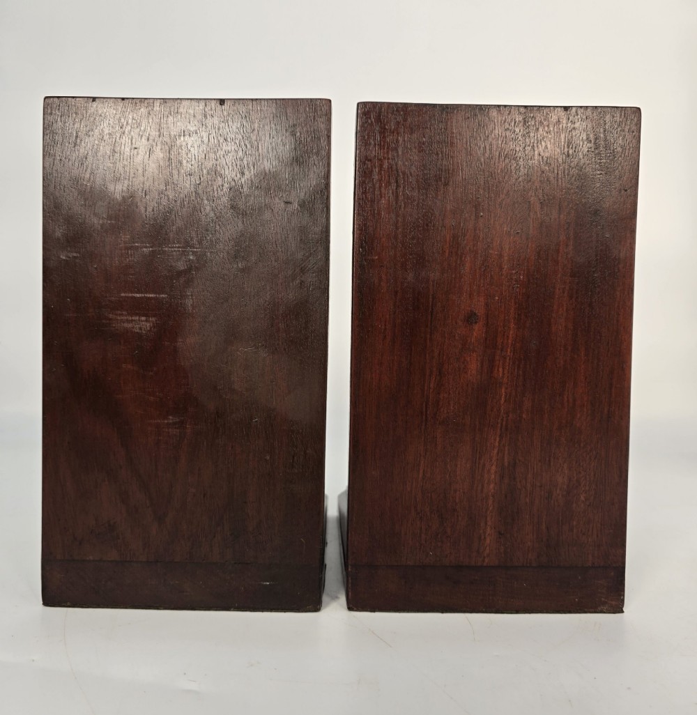 A pair of carved mahogany bookends featuring profile busts of children mounted on L-shaped wooden bases. View VIII