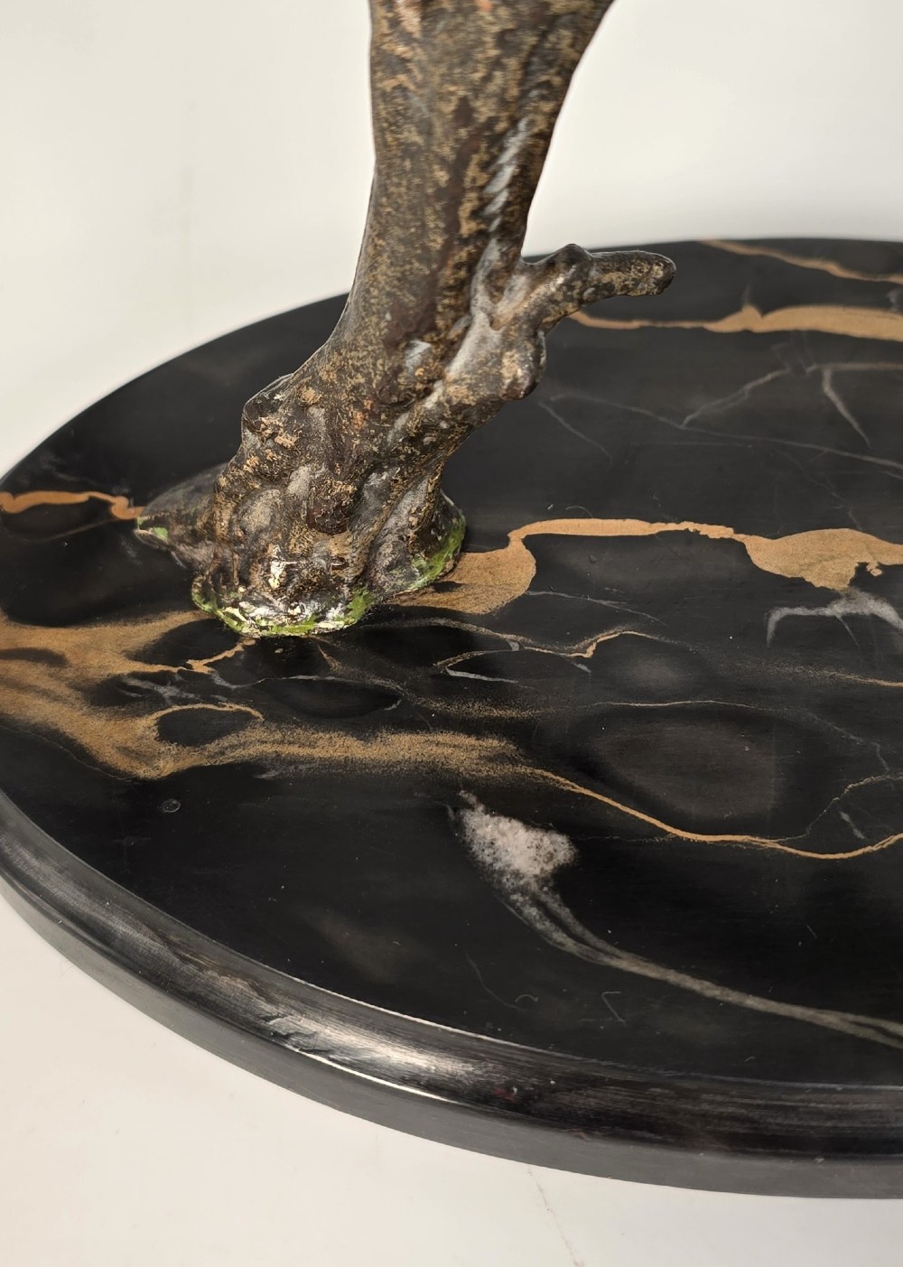 A cold-painted bronze sculpture featuring three blue and grey budgerigars perched on a leafy bronze branch, mounted on an oval dark marble base. View XII