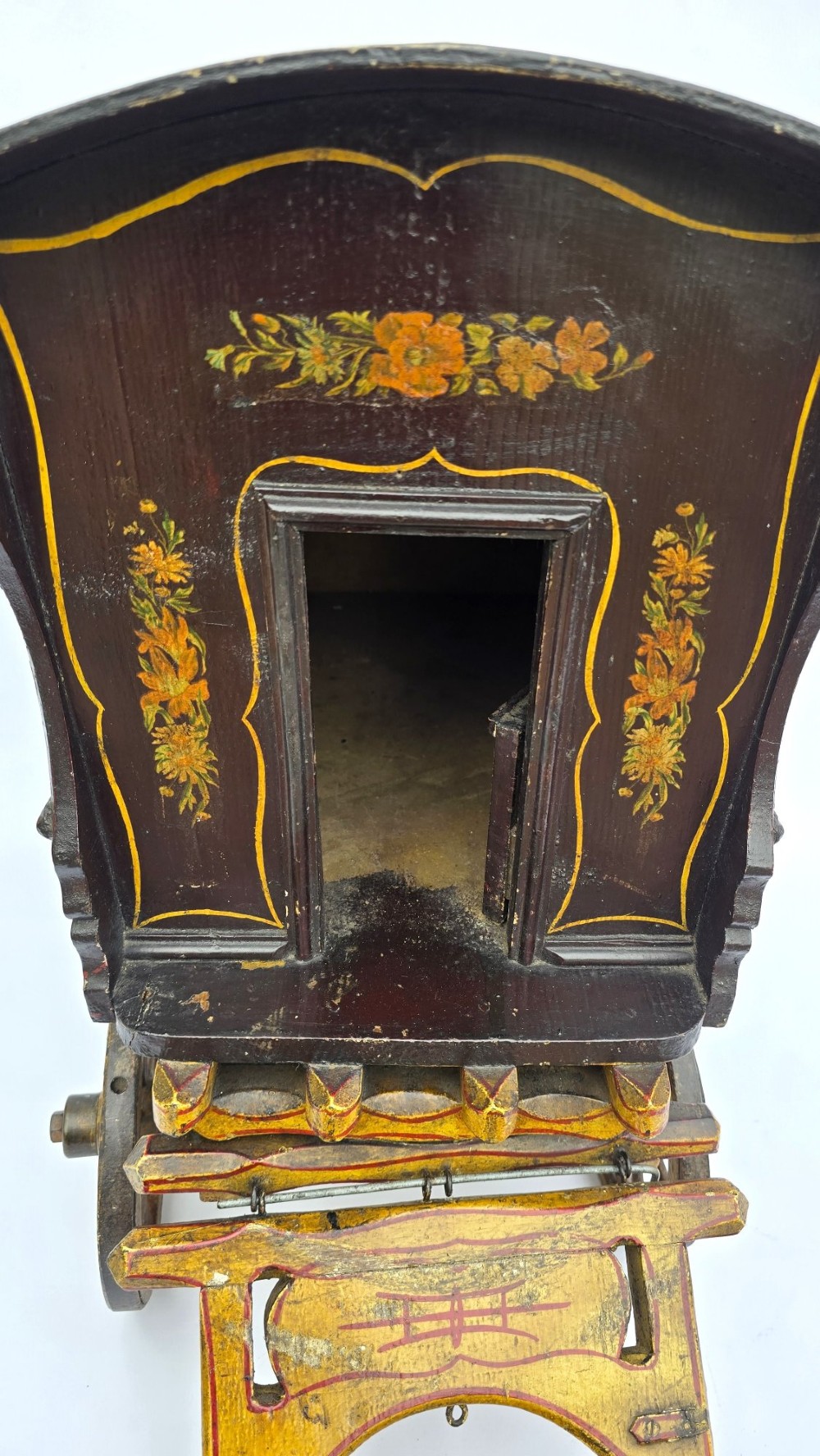 Hand-painted Edwardian wooden scale model of a Romani vardo caravan in dark brown and yellow with floral motifs and spoked wheels. View VIII