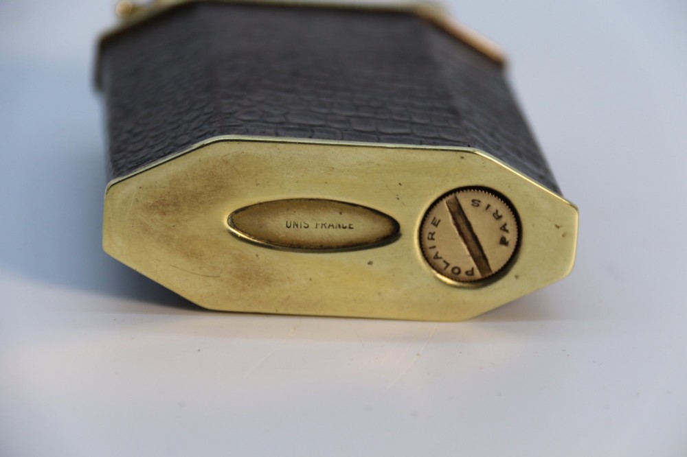 An Art Deco French table lighter featuring a textured brown leather-wrapped faceted body and a polished brass lift-arm ignition mechanism. View IX