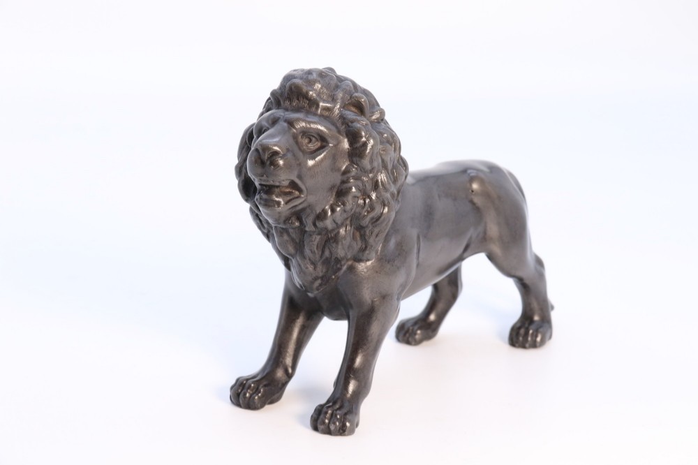 A dark patinated pewter sculpture depicting a standing male lion with a flowing mane and open mouth. View III