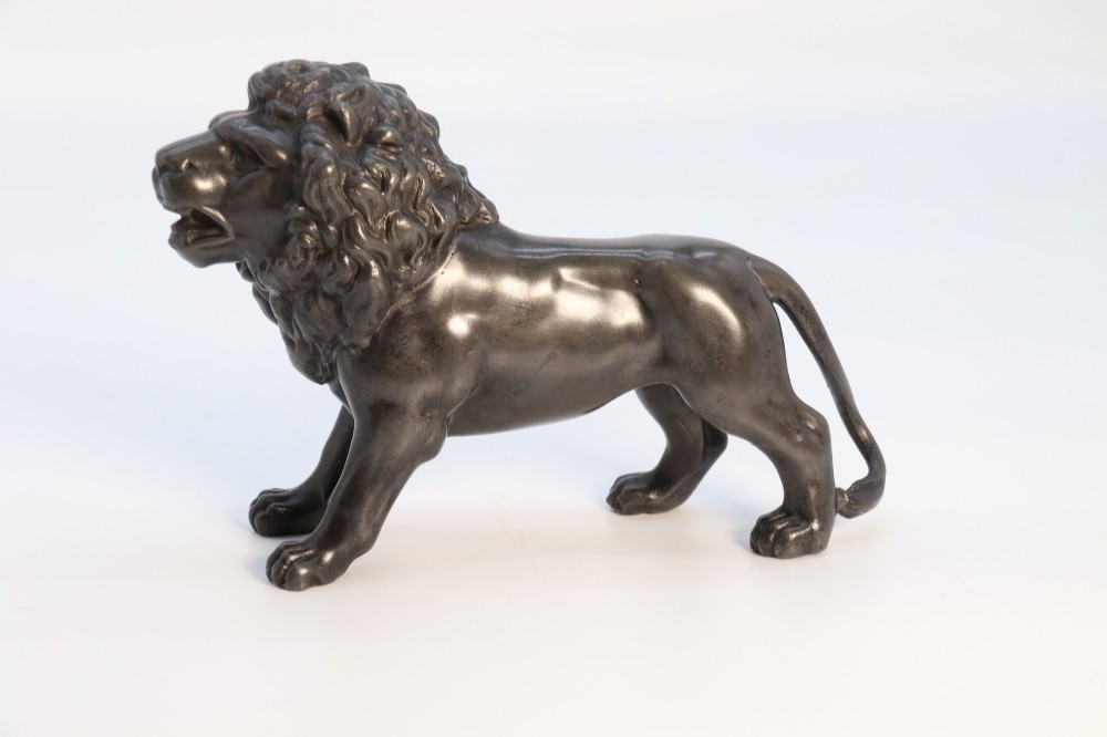 A dark patinated pewter sculpture depicting a standing male lion with a flowing mane and open mouth. View IV