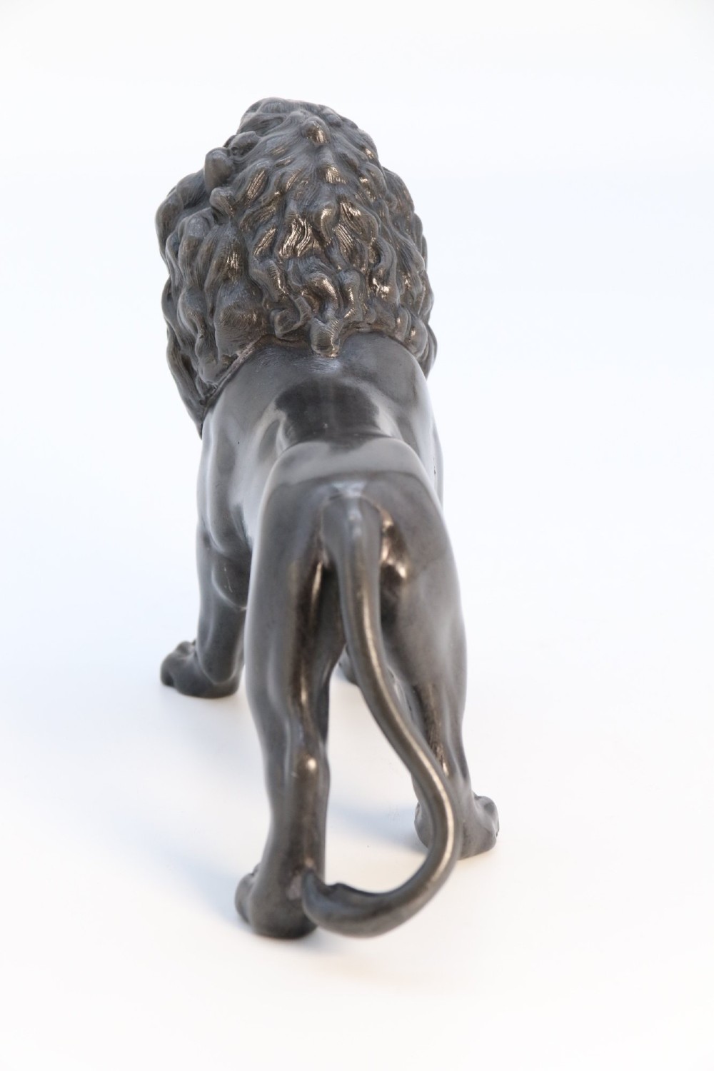 A dark patinated pewter sculpture depicting a standing male lion with a flowing mane and open mouth. View VI