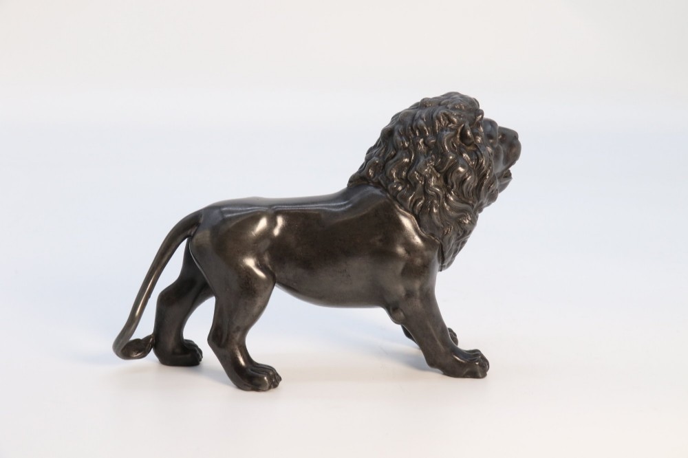 A dark patinated pewter sculpture depicting a standing male lion with a flowing mane and open mouth. View VIII