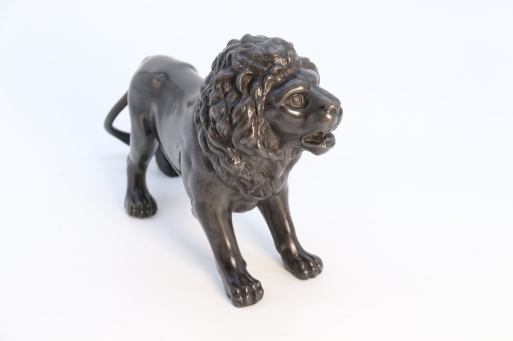 A dark patinated pewter sculpture depicting a standing male lion with a flowing mane and open mouth. View X