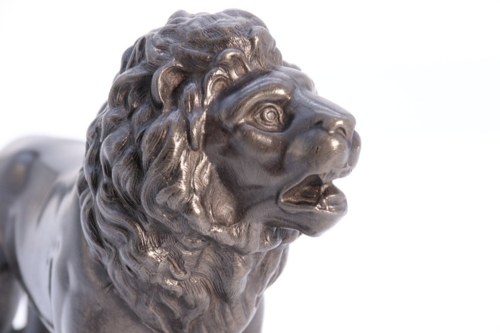 A dark patinated pewter sculpture depicting a standing male lion with a flowing mane and open mouth. View XIV