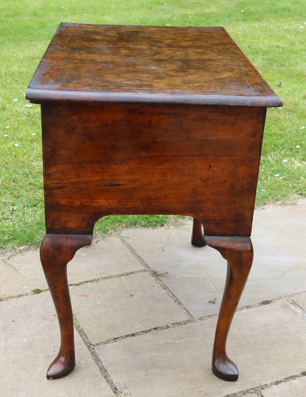 A George II burr elm lowboy table with three drawers, brass handles, a shaped apron, and cabriole legs. View XII