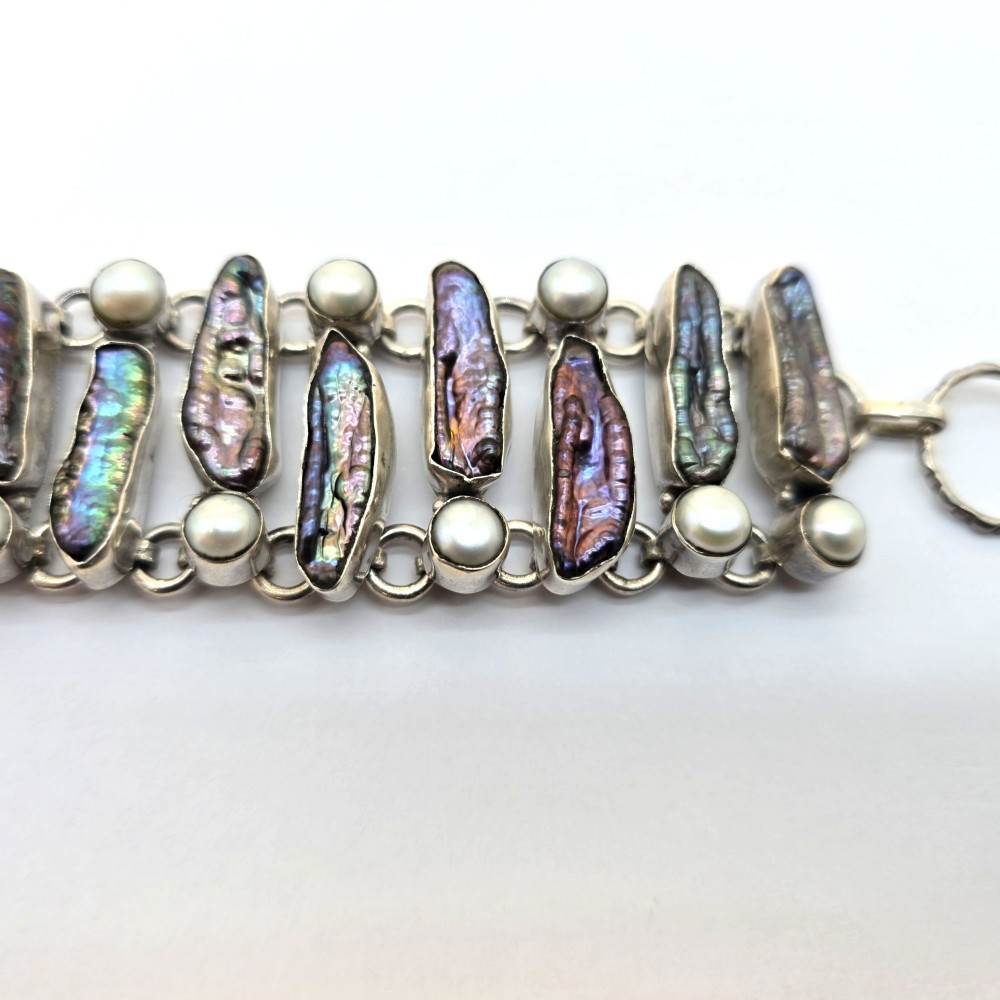 A 1960s Japanese silver jewellery set featuring an articulated link bracelet and a matching ring set with elongated, iridescent Biwa pearls and round white pearls. View VI
