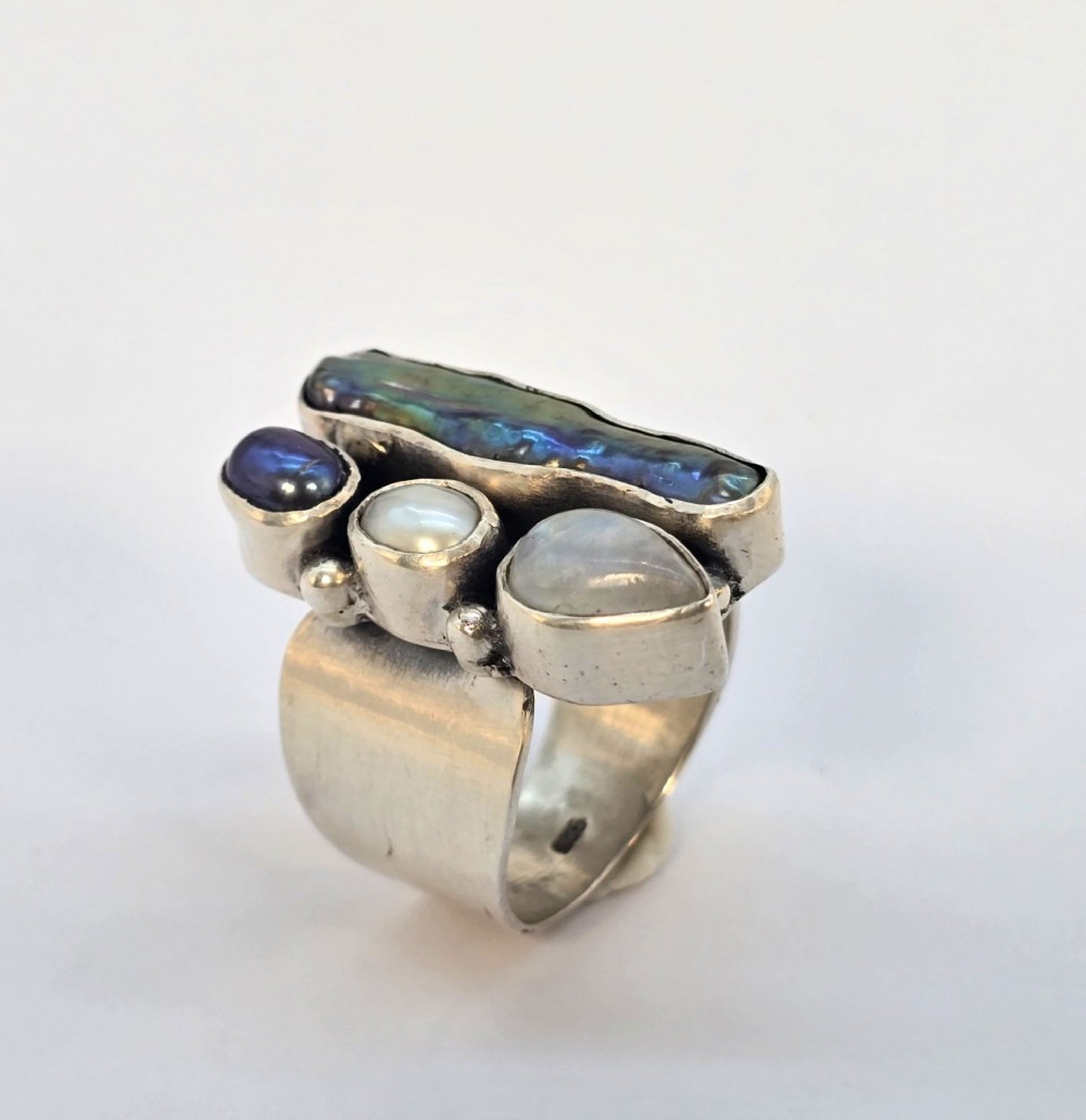 A 1960s Japanese silver jewellery set featuring an articulated link bracelet and a matching ring set with elongated, iridescent Biwa pearls and round white pearls. View IX