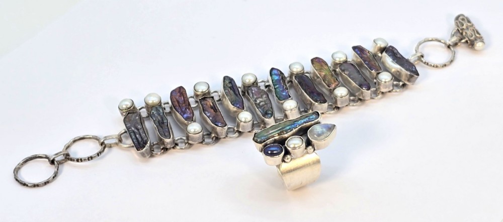 A 1960s Japanese silver jewellery set featuring an articulated link bracelet and a matching ring set with elongated, iridescent Biwa pearls and round white pearls. View XII