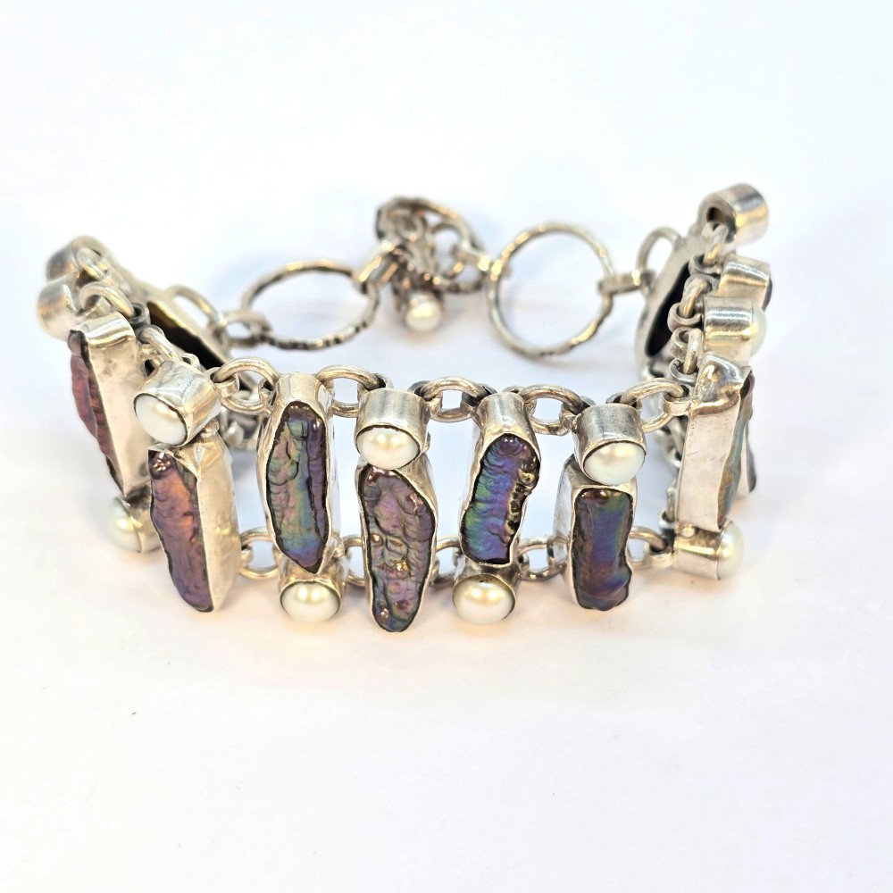 A 1960s Japanese silver jewellery set featuring an articulated link bracelet and a matching ring set with elongated, iridescent Biwa pearls and round white pearls. View XIII
