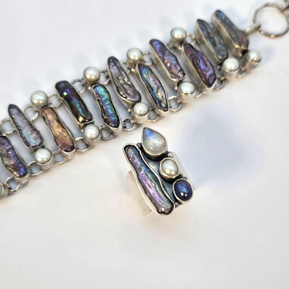 A 1960s Japanese silver jewellery set featuring an articulated link bracelet and a matching ring set with elongated, iridescent Biwa pearls and round white pearls. View XV