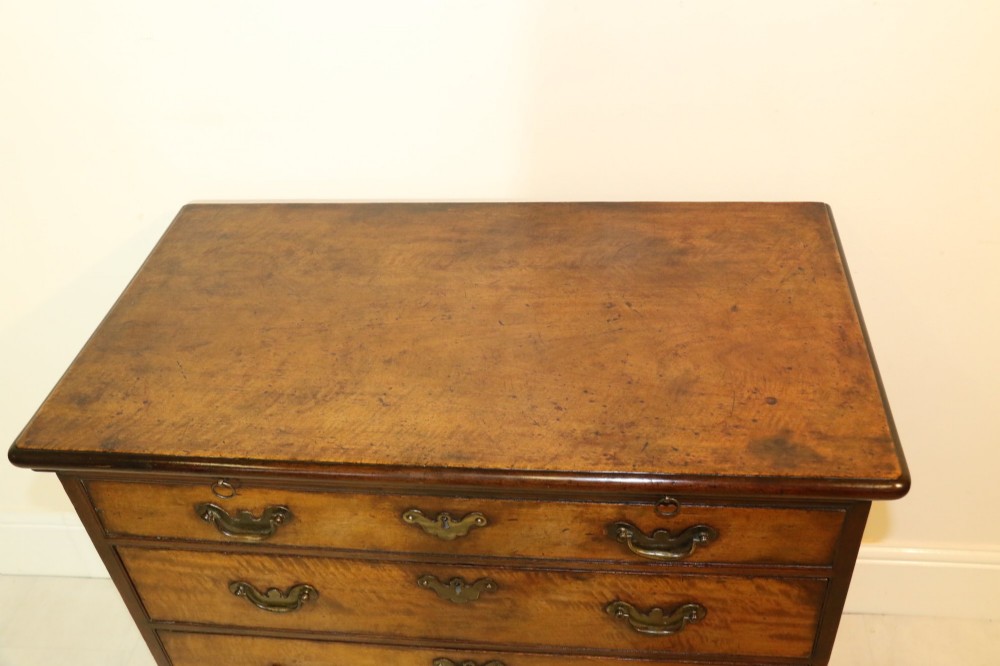 An 18th-century warm brown walnut bachelors chest of drawers with brass swing handles, a pull-out brushing slide, four graduated drawers, and bracket feet. View VI
