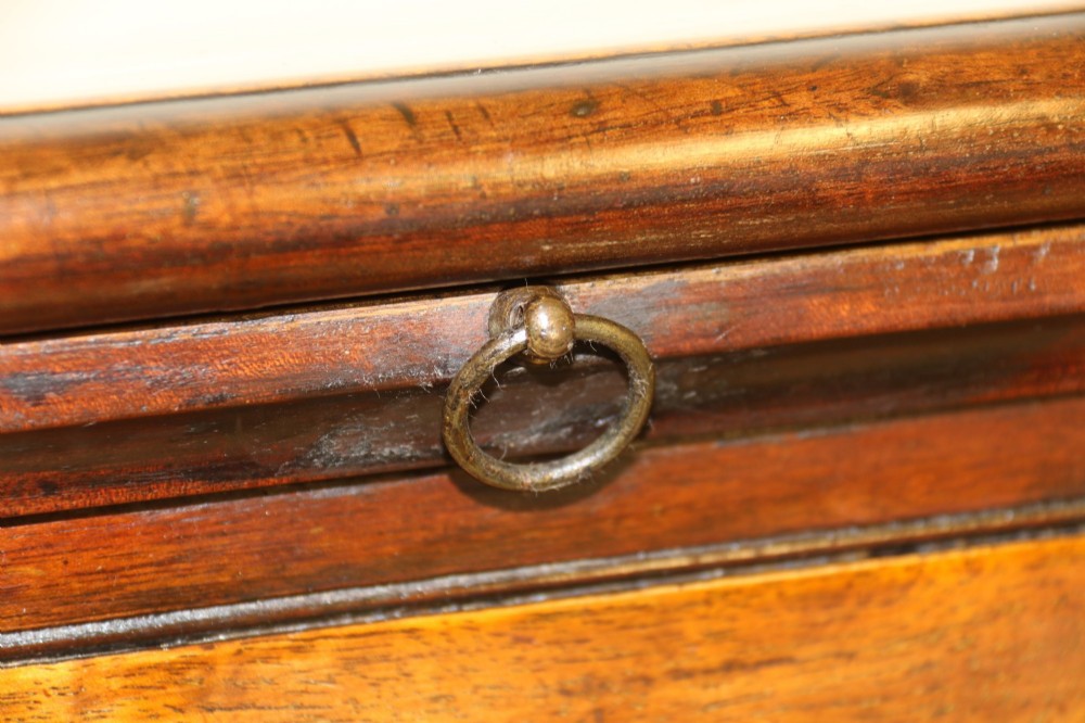 An 18th-century warm brown walnut bachelors chest of drawers with brass swing handles, a pull-out brushing slide, four graduated drawers, and bracket feet. View XI
