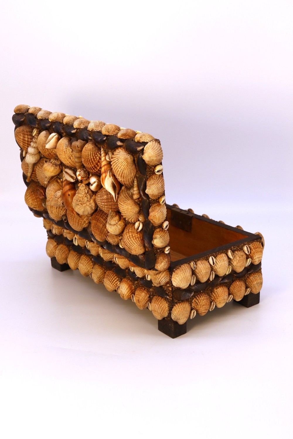A rectangular wooden box encrusted entirely with an assortment of natural seashells, supported by four short block feet. View XIV