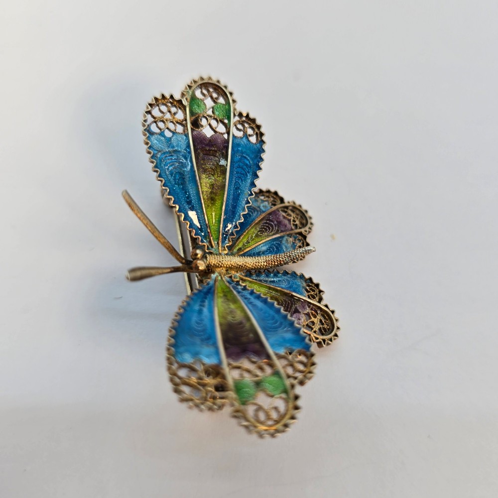 An Art Deco silver gilt butterfly brooch featuring blue, green, and purple enamel panels edged with wire filigree. View III