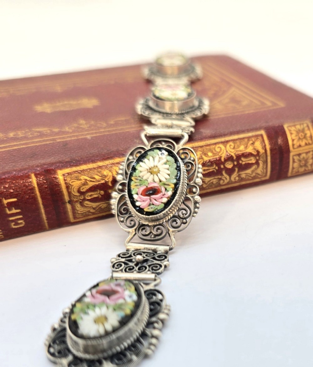 An Italian silver filigree link bracelet featuring oval micro mosaic panels with floral motifs set against a dark background. View XI