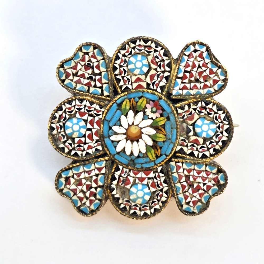 A floral-shaped 19th-century Italian micro mosaic brooch featuring colourful glass tesserae set inside an open velvet-lined tan leather box. View III