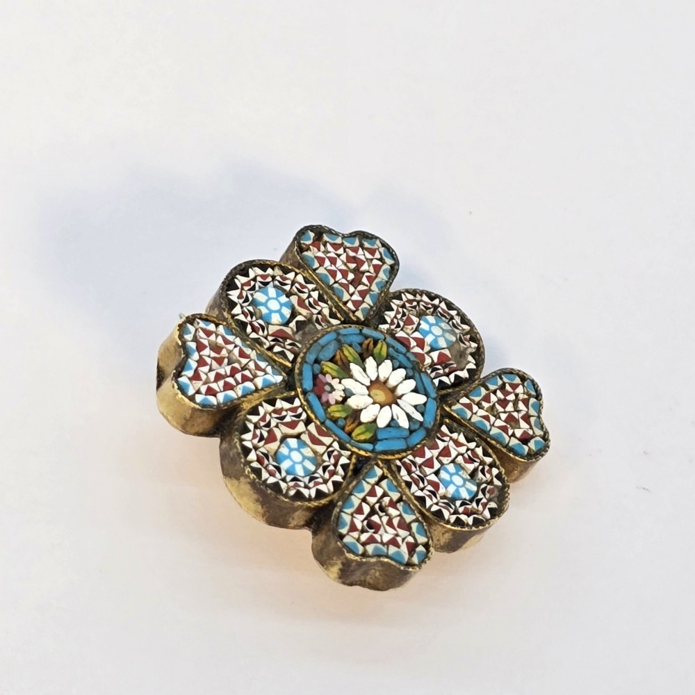 A floral-shaped 19th-century Italian micro mosaic brooch featuring colourful glass tesserae set inside an open velvet-lined tan leather box. View IV
