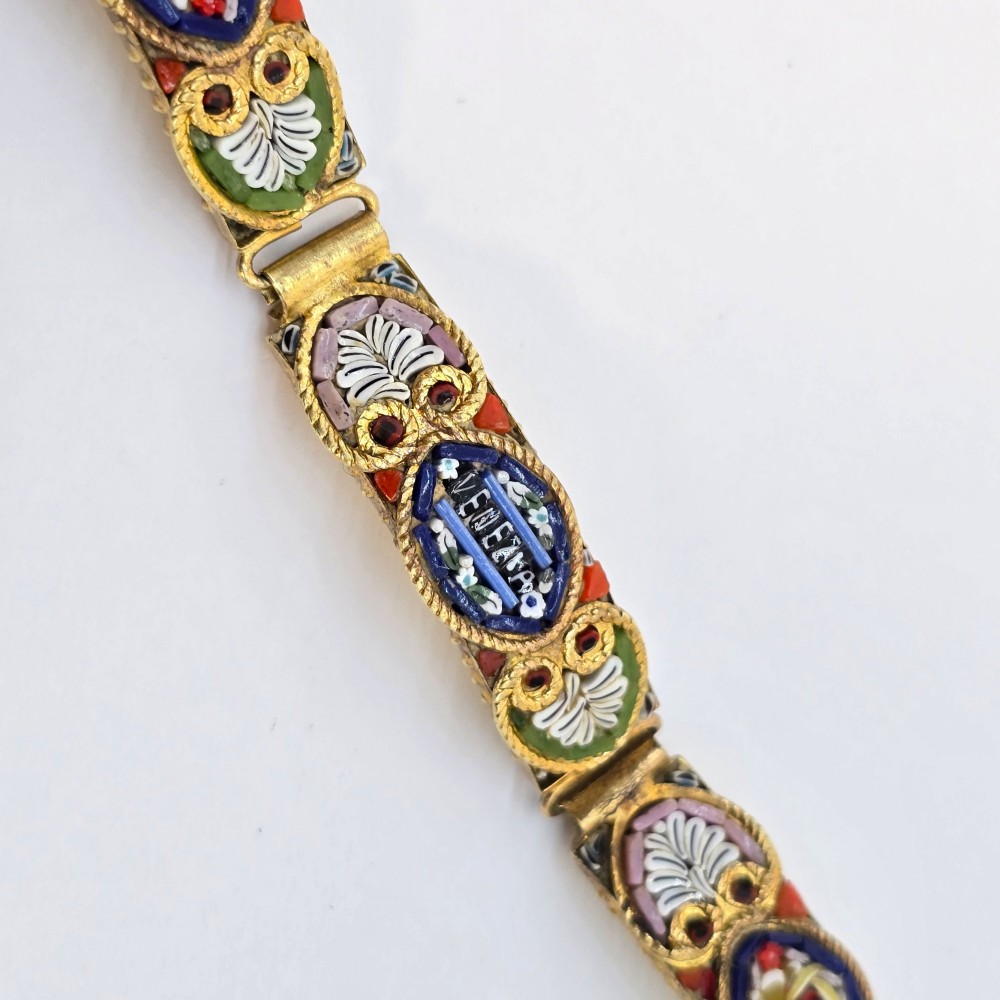 An antique gilt metal link bracelet featuring micro mosaic glass panels, including a central oval panel displaying the word Venezia in white lettering against a blue ground. View V