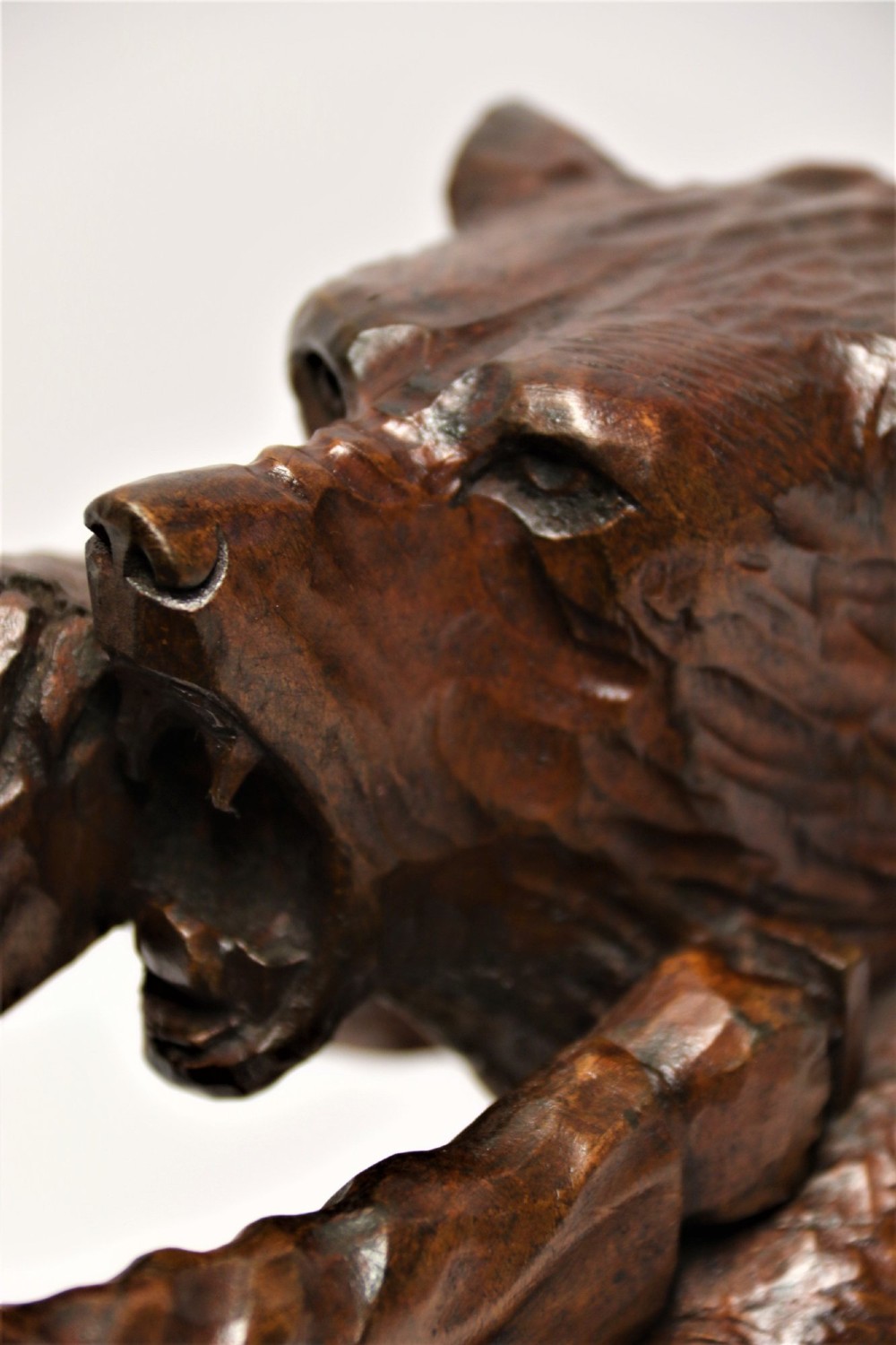 A detailed 19th-century carved walnut sculpture depicting a man in traditional attire struggling with a standing bear upon a carved log base. View IX