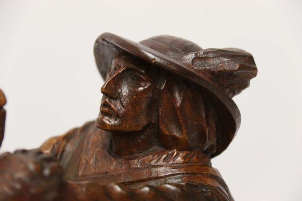 A detailed 19th-century carved walnut sculpture depicting a man in traditional attire struggling with a standing bear upon a carved log base. View XII