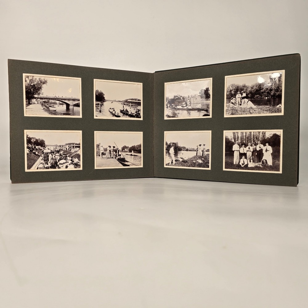 A set of three dark green cloth-bound Edwardian photograph albums stacked diagonally, featuring gold-embossed lettering and a geometric motif. View XI