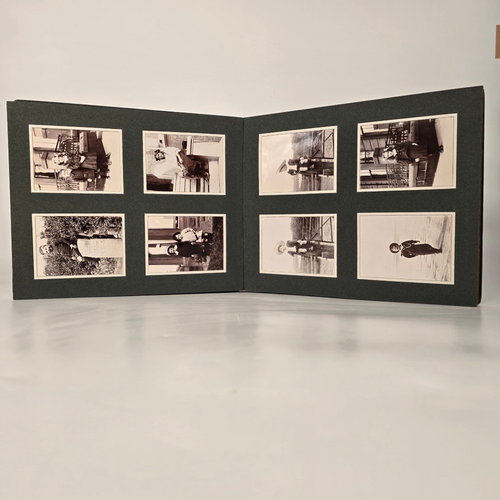 A set of three dark green cloth-bound Edwardian photograph albums stacked diagonally, featuring gold-embossed lettering and a geometric motif. View XIII