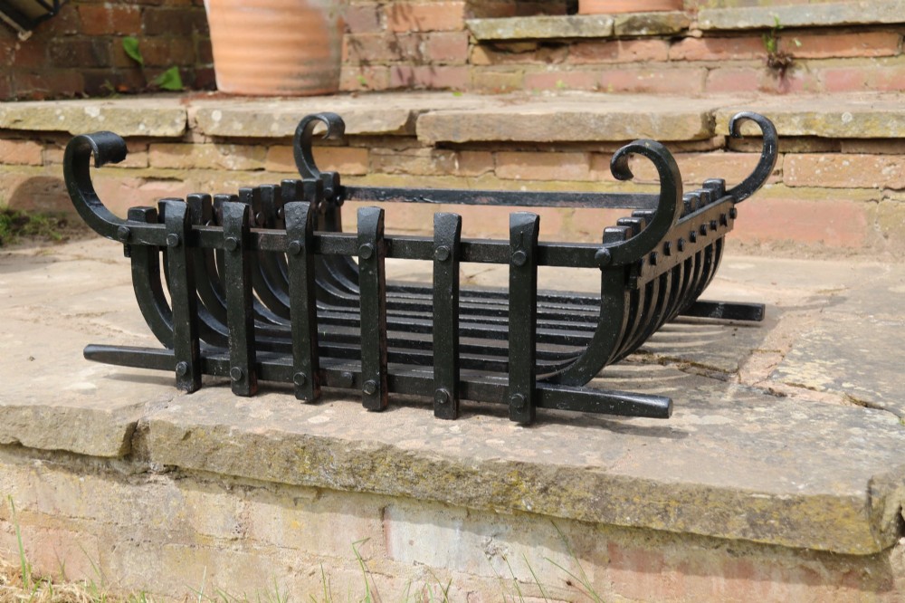 A black wrought iron fire basket featuring vertical slatted bars, hand-riveted joints, and scrolled corner handles. View V