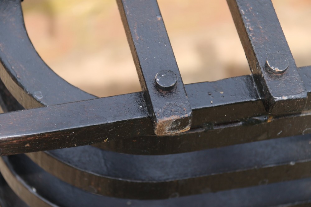 A black wrought iron fire basket featuring vertical slatted bars, hand-riveted joints, and scrolled corner handles. View VIII