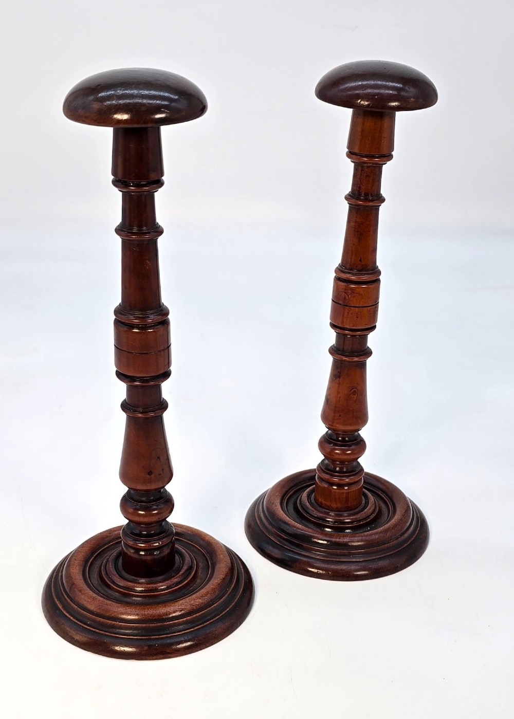 A pair of turned early eighteenth-century yew wood wig stands featuring domed tops, knopped baluster shafts, and turned circular bases. View II