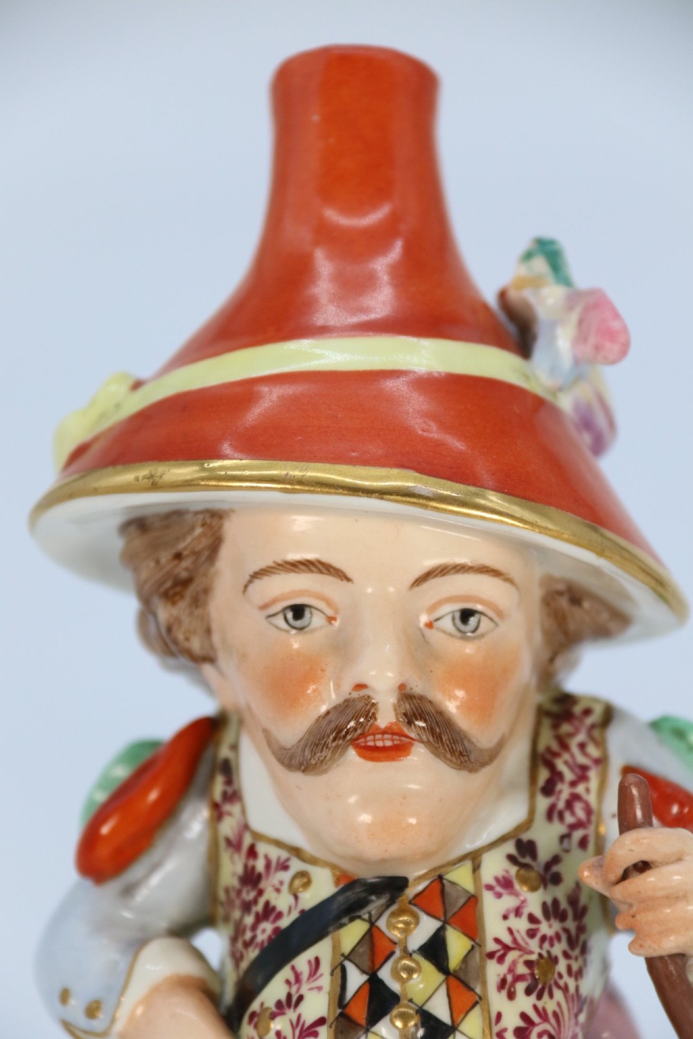 A pair of 19th-century polychrome Samson porcelain figures depicting dwarves wearing oversized brimmed hats and patterned waistcoats on mound bases. View XIV