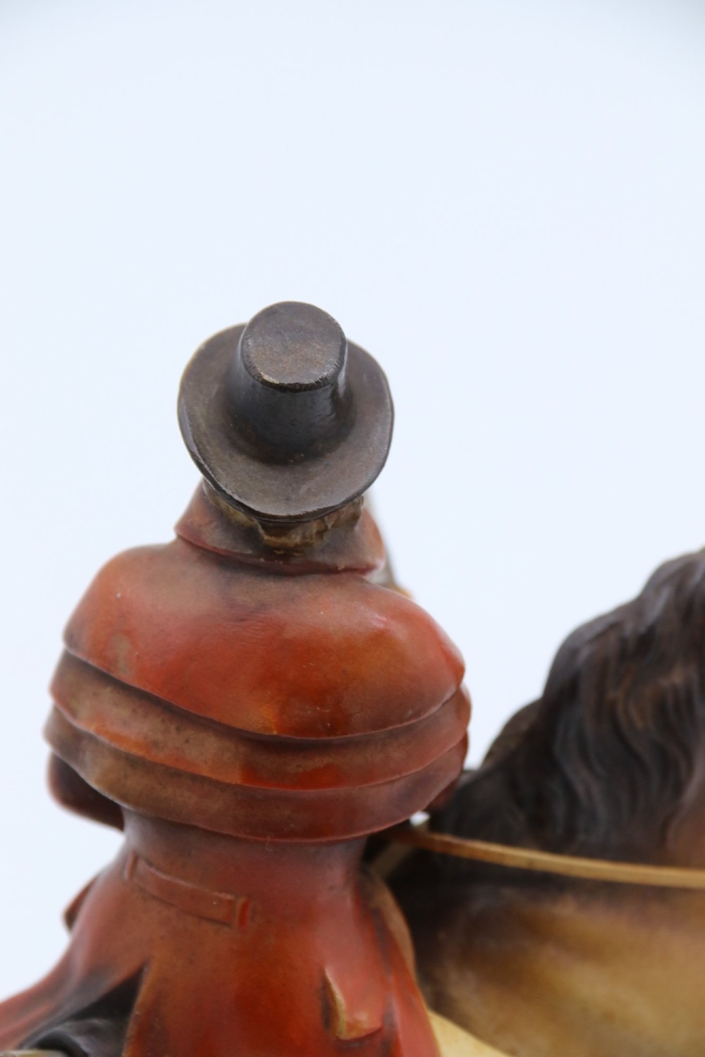 An Art Deco cold-painted metal table lighter depicting a masked figure on horseback mounted on a wooden base. View XI