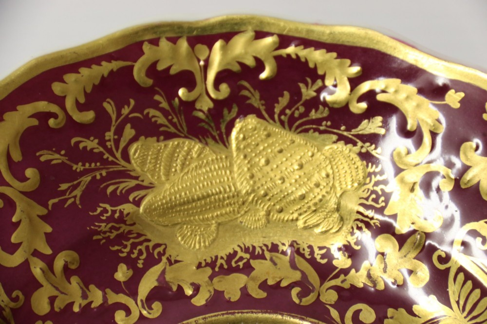 An early nineteenth-century Regency Spode porcelain cabinet cup and saucer featuring deep crimson ground decorated with heavy gilded scrollwork and shell motifs. View V