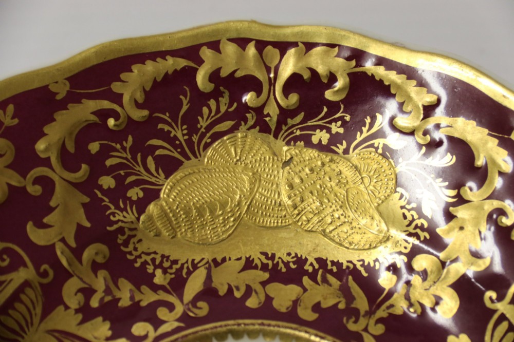 An early nineteenth-century Regency Spode porcelain cabinet cup and saucer featuring deep crimson ground decorated with heavy gilded scrollwork and shell motifs. View VI