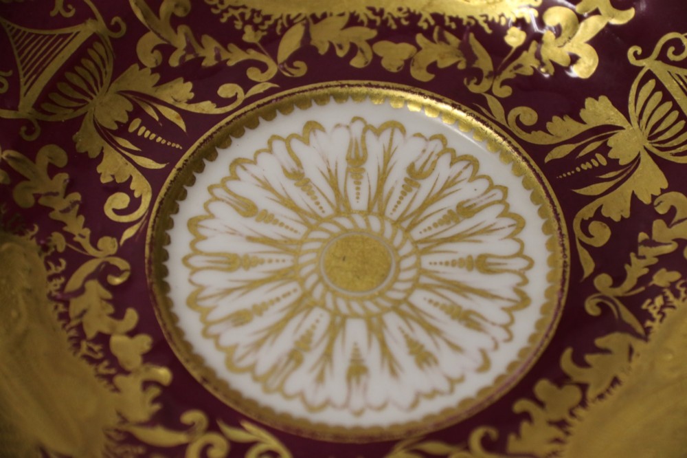 An early nineteenth-century Regency Spode porcelain cabinet cup and saucer featuring deep crimson ground decorated with heavy gilded scrollwork and shell motifs. View VII